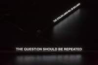 Two sentences are projected in white on a dark space: 