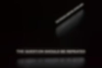 Two sentences are projected in white on a dark space: 