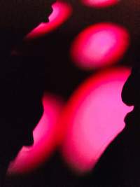 Pink spotlights illuminate a dark surface.