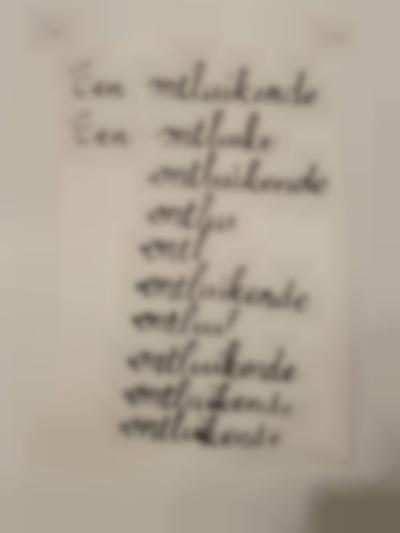 A white A4 sheet is stuck to a wall. 