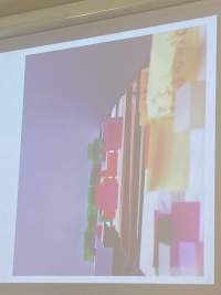 A slide with an image is being projected. The image is a photograph of a shelf of books annotated with colourful sticky notes.