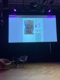 A large projected image shows a website page with an image and some text. The image shows a torso with the words 