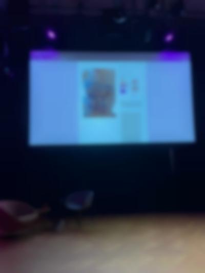 A large projected image shows a website page with an image and some text. The image shows a torso with the words 