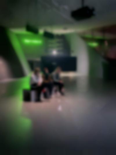 Students sit inside the exhibition *Feed me. Cheat me. Eat me.* by Janis Rafa. EYE Filmmuseum, Amsterdam, 2023.