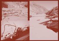 Red tinted book spread, with three photographs. The photographs show a desert area, a wire fence and two half buried unidentifiable structures.