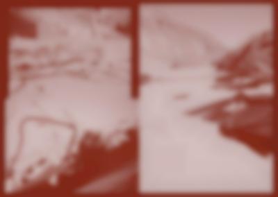 Red tinted book spread, with three photographs. The photographs show a desert area, a wire fence and two half buried unidentifiable structures.