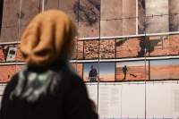 Person looks at a large screen, which has images and text printed on.