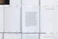 Close-up of a large screen. The installation is made from several A4 sheets attached to each other with metal rings. The title in one of them reads 