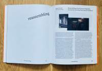 A book lies open. On the top page, 