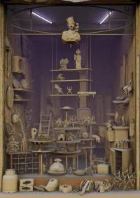 Art installation, consisting of a shop window where several clay-toned objects have been put on display.