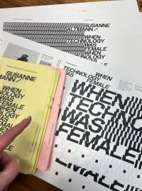 Booklets of yellow and pink pages sit on top of white book jackets, where the title 