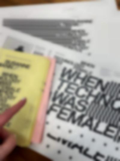 Booklets of yellow and pink pages sit on top of white book jackets, where the title 